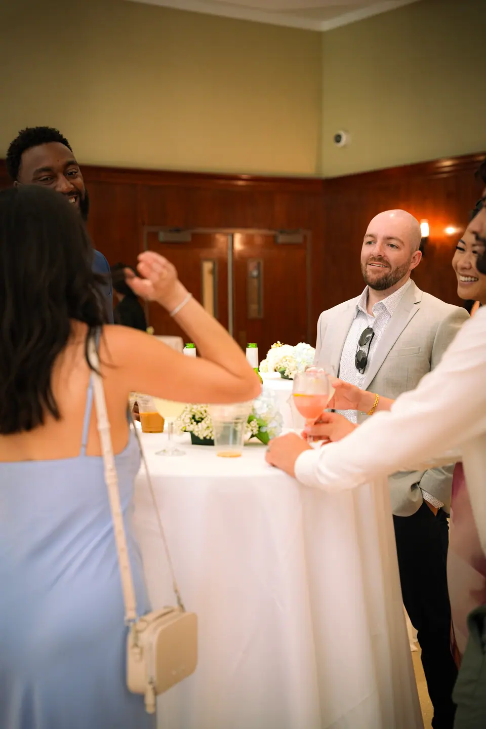 Guests laughing together around a flower-filled table