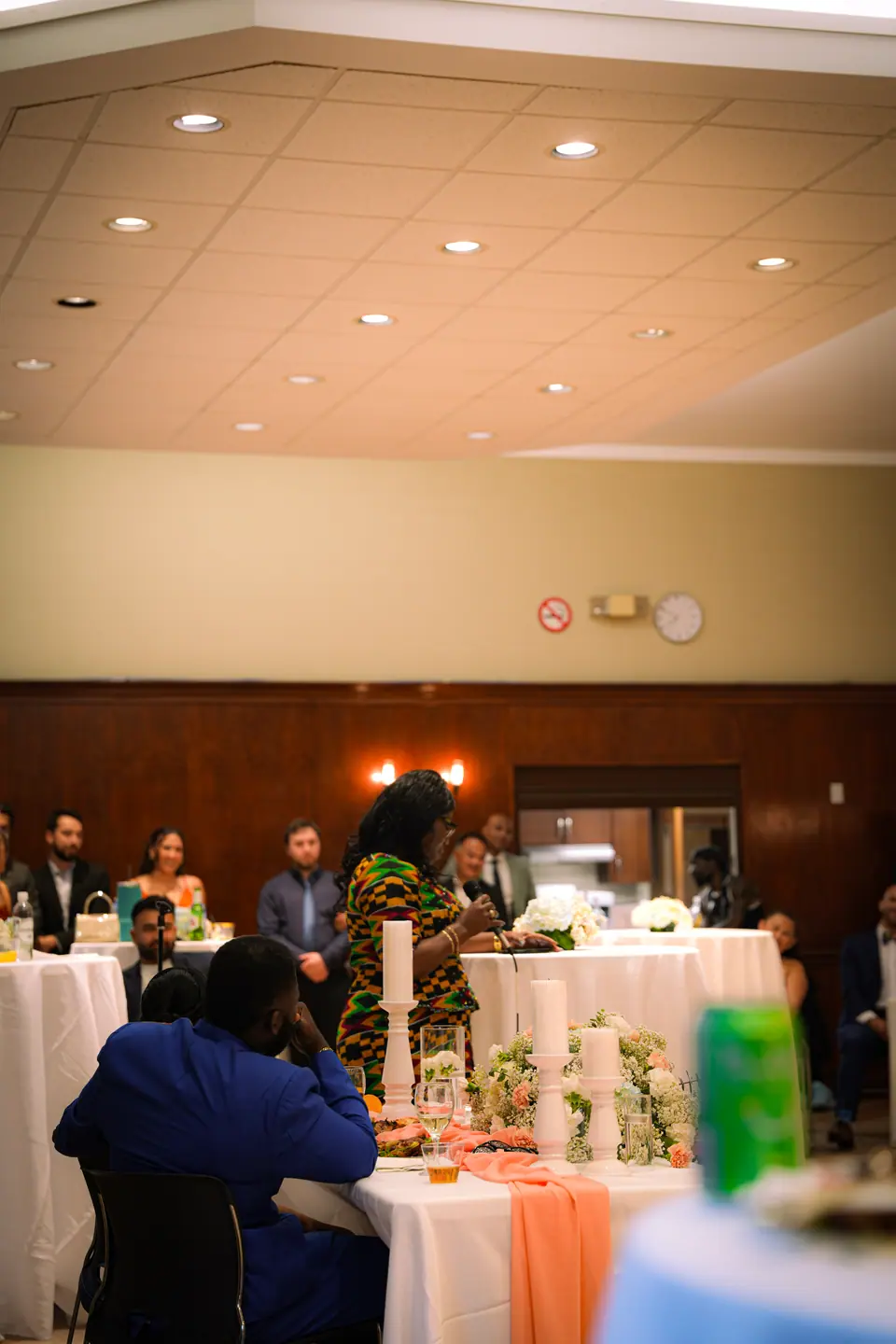 The bride speaking to guests across the reception room